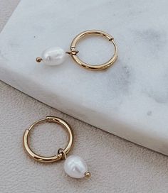 Have the option of two styles in one earring set! Swap out the pearls for the 18K gold hoops for a second look, waterproof and perfect for any occasion. Length: 11/4" Pear Charm 18k Gold plated Waterproof Non-tarnishing Hypoallergenic Care tips: Store jewelry in a small plastic zip lock Use a jewelry cloth to clean everyday oils off Avoid contact with chemicals such as hairspray, lotions, perfumes, etc. Gold Hypoallergenic Pearl Huggie Earrings, One Earring, Store Jewelry, Pearl Charms, Gold Hoops, Charm Earrings, Earring Set, Pear, Lotion