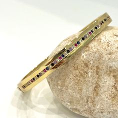 Flawless CZ encrusted hard bangle is a really special piece. Embrace your beauty and highlight your pretty appearance by wearing it, featuring an exquisite design. It is definitely a unique find! It is a hinged bracelet featuring 1 row of multi colored CZ stones adorning the center of the band on one side. This is a seriously pretty bangle that packs a sparkly punch! such an effortless and easy way to dress up any outfit, it makes a beautiful gift or a special treat for yourself.- Stones Materia Luxury Multicolor Bangle, Jeweled Crystal Bangle Bracelet, Multicolor Stone Bangle For Gift, Multicolor Stone Bangle As Gift, Cubic Zirconia Multi-stone Bangle, Multi-stone Cubic Zirconia Bangle, Elegant Multicolor Stone Bangle, Elegant Jeweled Multicolor Bangle, Elegant Multicolor Jeweled Bangle