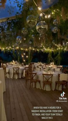 an outdoor dining area with tables, chairs and chandeliers hanging from the ceiling