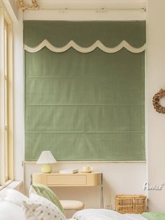 a bed sitting under a window next to a green roller shades covering the window sill