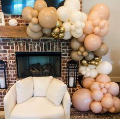 a living room filled with balloons and a white chair in front of a fire place