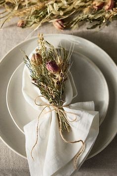 a white plate topped with a napkin and flowers