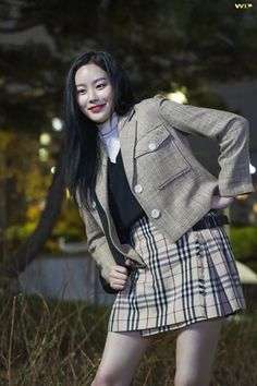 a woman in a skirt and jacket posing for the camera