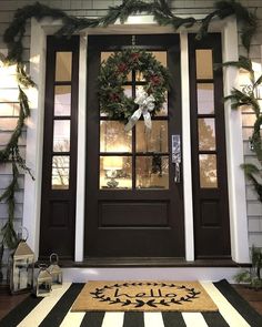 the front door is decorated for christmas with wreaths