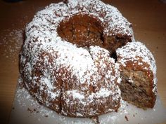 a cake with powdered sugar on top sitting on a cutting board