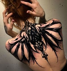 the back of a woman's body with black and white ink art work on it