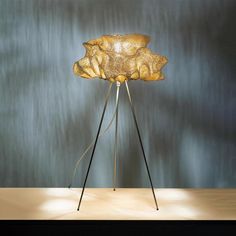 a lamp that is sitting on top of a wooden table in front of a wall