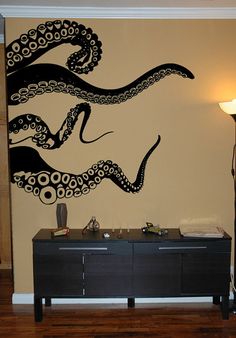 an octopus painted on the wall next to a dresser in a room with wood floors