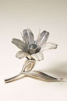 a silver vase with a flower in it