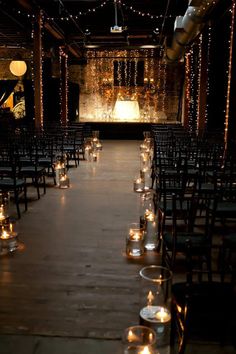 rows of chairs with lit candles on them