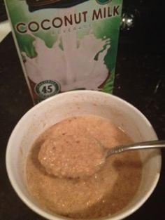 a bowl of oatmeal next to a carton of coconut milk