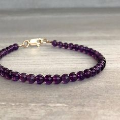 Amethyst Bead Bracelet with silver or gold clasp | February Birthstone Jewelry | This gemstone bracelet features natural amethyst crystals. The smooth Amethyst beads are a lovely deep purple. The simple design allows the beauty of the stones to shine. This bracelet is perfect on its own, or stacked with your favorite bracelets. At checkout, choose a silver or gold Everyday Purple Hand-strung Jewelry, Everyday Purple Round Beaded Bracelets, Everyday Amethyst Natural Stone Bracelets, Everyday Amethyst Natural Stone Bracelet, Classic Purple Round Bead Jewelry, Faceted Amethyst Beads Bracelets, Amethyst Bracelets With Faceted Beads, Everyday Purple Round Beads Bracelets, Everyday Amethyst Gemstone Bracelets