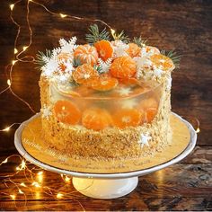 there is a cake with oranges on it and lights in the backround