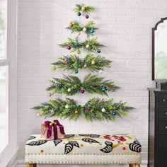 a small christmas tree is hanging on the wall next to a bench with presents under it