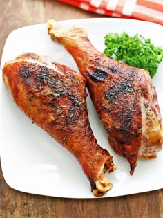 two pieces of chicken on a plate with broccoli