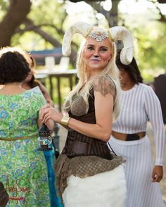 a woman dressed in costume standing next to other women