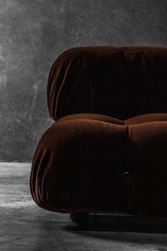 a brown couch sitting on top of a floor next to a black and white wall