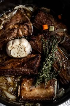 a pot filled with meat and vegetables sitting on top of a table next to a knife