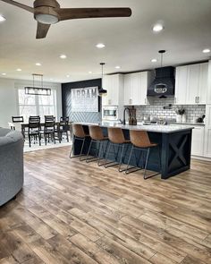 a large open kitchen and living room with wood flooring