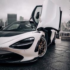 a white and black sports car with its doors open