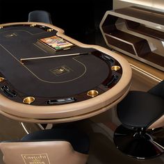 a black table with gold trim around it and two chairs at the base, in front of an entertainment center