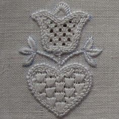 a close up of a piece of cloth with two hearts in the center and leaves on it