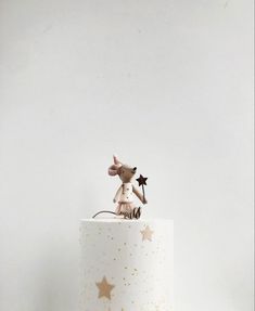 a white cake with gold stars and a mouse figurine on top