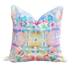 a colorful pillow with an abstract design on the front and back, sitting on a white surface