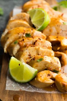 chicken and limes on a wooden cutting board