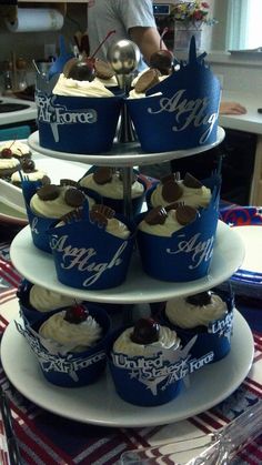 a three tiered cake stand with cupcakes on it