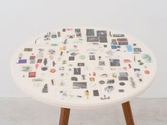 a white table topped with lots of pictures and magnets on it's side