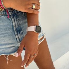 a close up of a person with an apple watch on their wrist and her jeans shorts