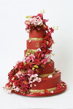 a three tiered red wedding cake decorated with flowers