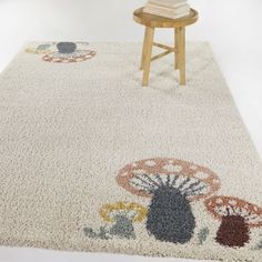 a white rug with colorful designs on it and a wooden chair in the corner next to it