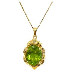 This wonderful vintage pendant presents a large oval peridot in a rich 18 karat gold crest-shaped frame with diamond accents. Peridot is the August birthstone. Mark a graduation, anniversary, or important milestone! This pendant would be perfect as a regal statement piece. The peridot weighs 15.63 carats with a total of 0.01 carat in small accent diamonds that make a perfect bright sparkle amid the rich warm tones of the gold. The pendant is 1.02-inch long on this 14 karat gold 18.5 inch long box chain. We can help with a different chain (or no chain) if requested. This pendant and chain was originally priced at $3000. This pendant will make a wonderful gift! The pendant details are: Metal Quality: 18 karat (stamped) Complete Weight: 3.85 grams Measurements of Pendant: 1.02 inch (26 mm) lo August Birthstone Necklace, Stone Necklaces, August Birthstone, Peridot Gemstone, Green Diamond, Vintage Pendant, August Birth Stone, Diamond Clarity, Gemstone Colors