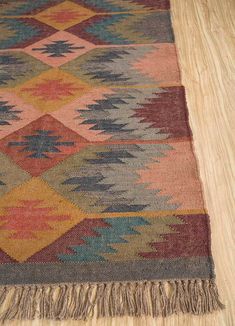 a multicolored rug with fringes on the floor