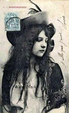 an old photo of a woman with long hair and a hat on top of her head