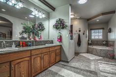 a large bathroom with two sinks and a bathtub next to a walk in shower