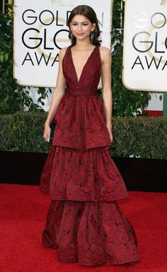 a woman in a red dress standing on a red carpet