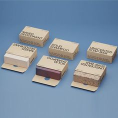 six boxes of soap sitting next to each other on a blue surface with white writing