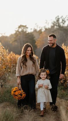 a man, woman and child walking through a field