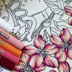 four different colored pencils sitting next to each other on top of a flowered table cloth