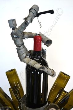 a wine bottle with some pipes sticking out of it's top, and bottles in the bottom