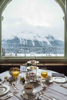 a table set with plates and silverware in front of a window overlooking the mountains