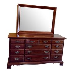 a wooden dresser with a mirror on top and drawers below it, against a white background