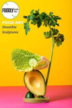 an avocado and lettuce sculpture on top of each other in front of a yellow background