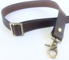 a pair of scissors on a brown leather belt with brass hardware and metal clasps