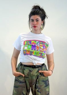 This is a funky 80s vintage summer graphic tee! It's a soft bright white, thin, semi sheer 50/50 t-shirt with a neon multicolor vinyl graphic that reads "Fun N Sun" in stylized letters. It has cool beachy, tropical and tribal imagery including a palm tree, surfboards, spirals, a sailboat and a graffiti MTV style face. Light and whimsical, and perfect for summer play in the surf, or the perfect retro gift for someone who misses California! This tee shirt is in very good clean freshly laundered condition, no flaws or wear noted. The label reads "Fun 'N Sun, Large, 50% Cotton, 50% Polyester, Made in USA." It may have been made as an oversized Youth Large, as it fits like an Adult Unisex size Small to Medium, and it measures: Chest - 36 inches, Shoulders - 17 inches, Sleeves - 6 inches, Length 1980s New Wave, Normal Fashion, California Surfer, Miss California, Summer Graphic Tee, Beach California, Vintage Shorts, Vintage Summer, New Wave