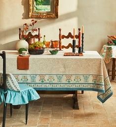 a dining room table with chairs and a painting on the wall