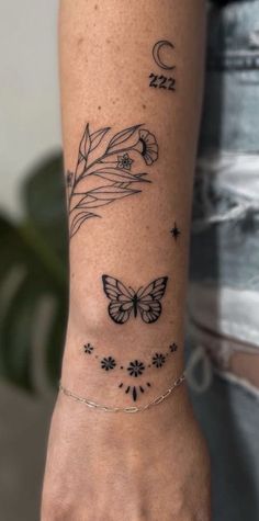 a woman's arm with tattoos on it and butterflies in the sky above her